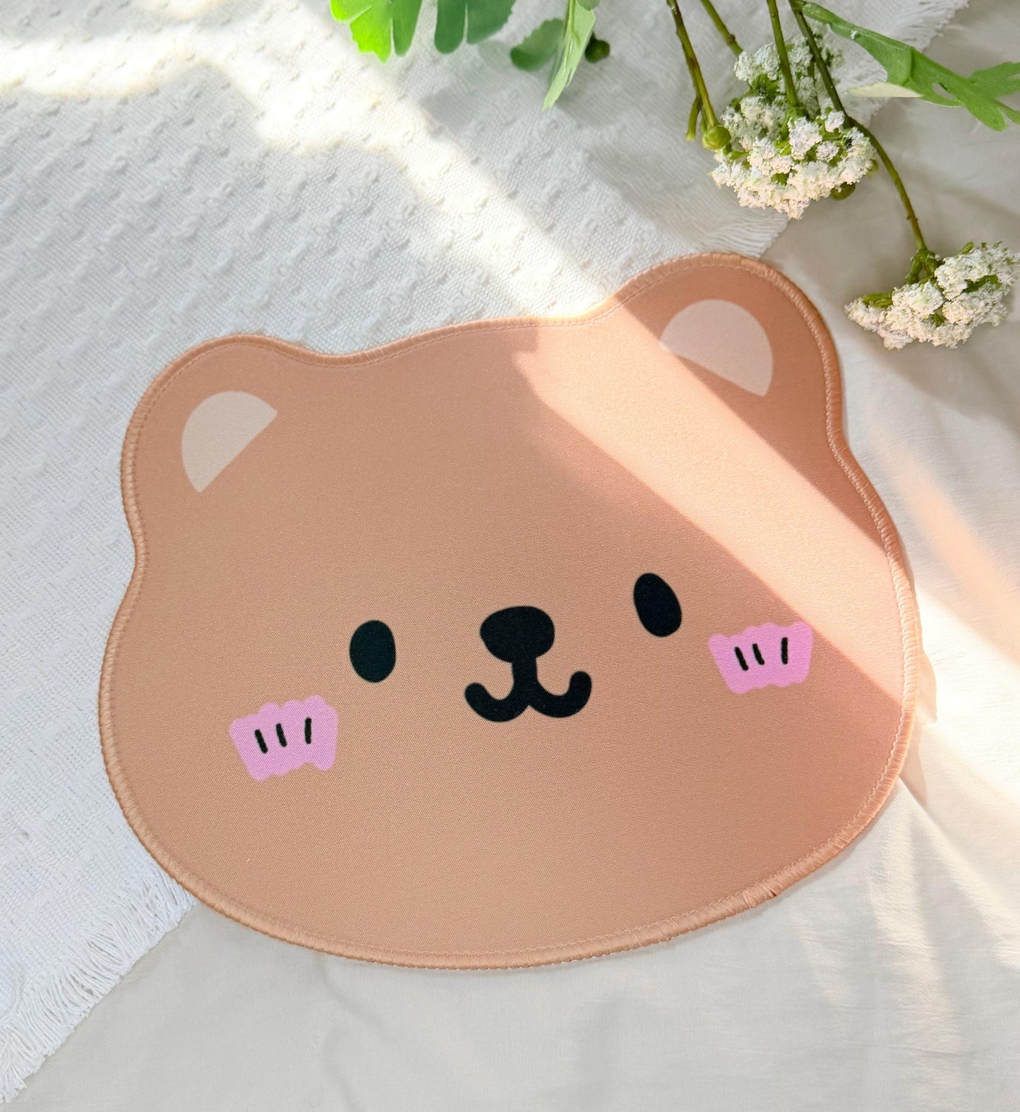 A mouse pad of a cute Kawaii brown bear face