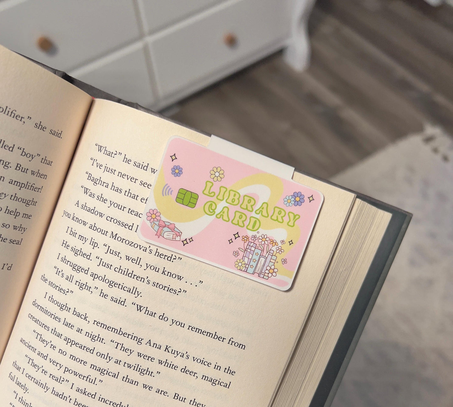 A magnetic bookmark in a cartoon style library book card that is pink and green with 70 styles flowers