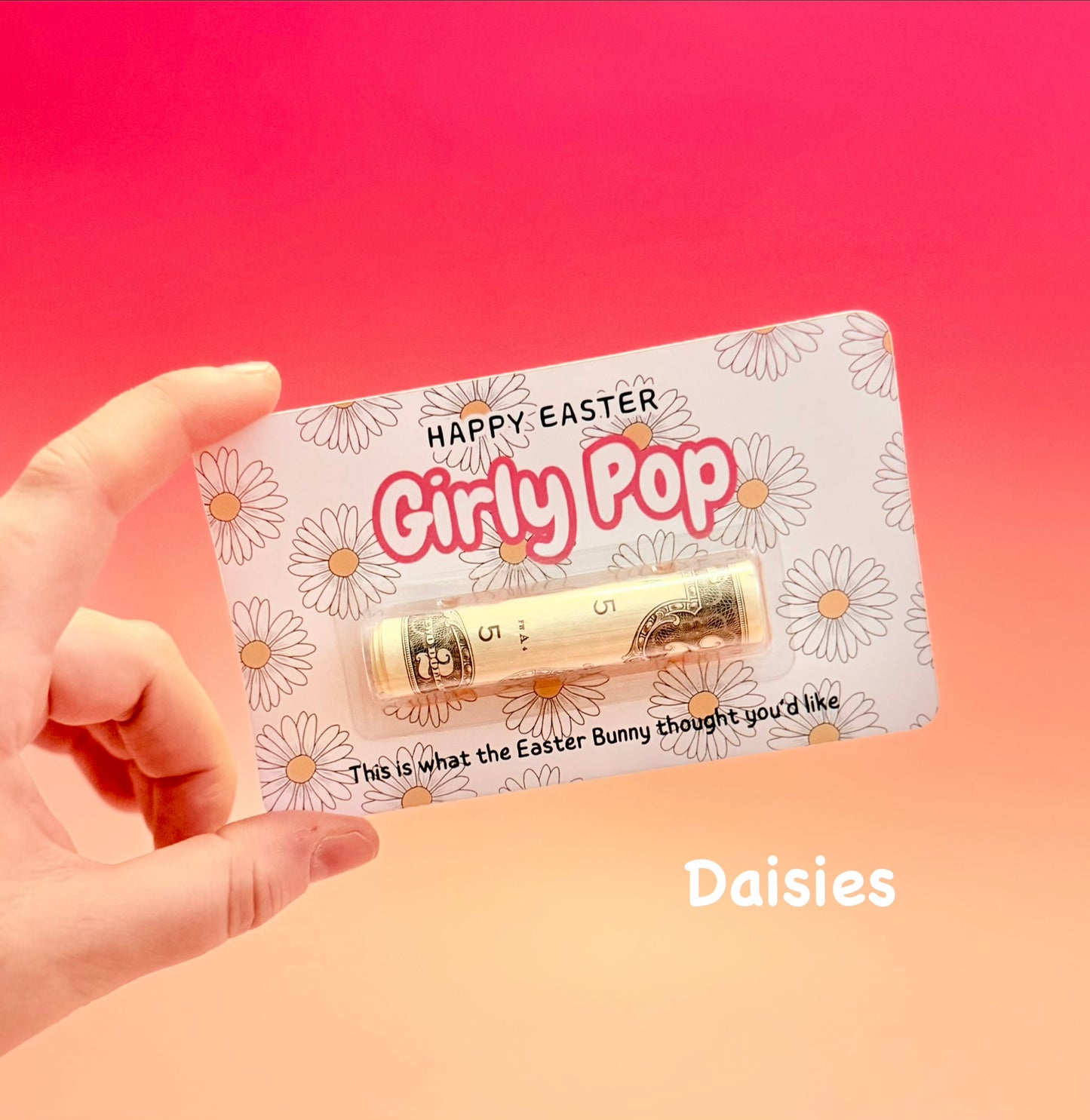 Hand holding a product with 'Happy Easter Girly Pop' packaging against a gradient pink and peach background.
