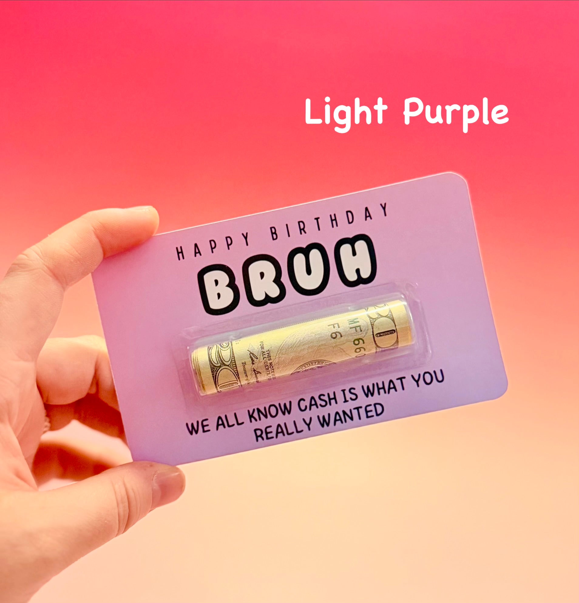 Light purple card with gold money roll and text, held by a hand against a pink background.