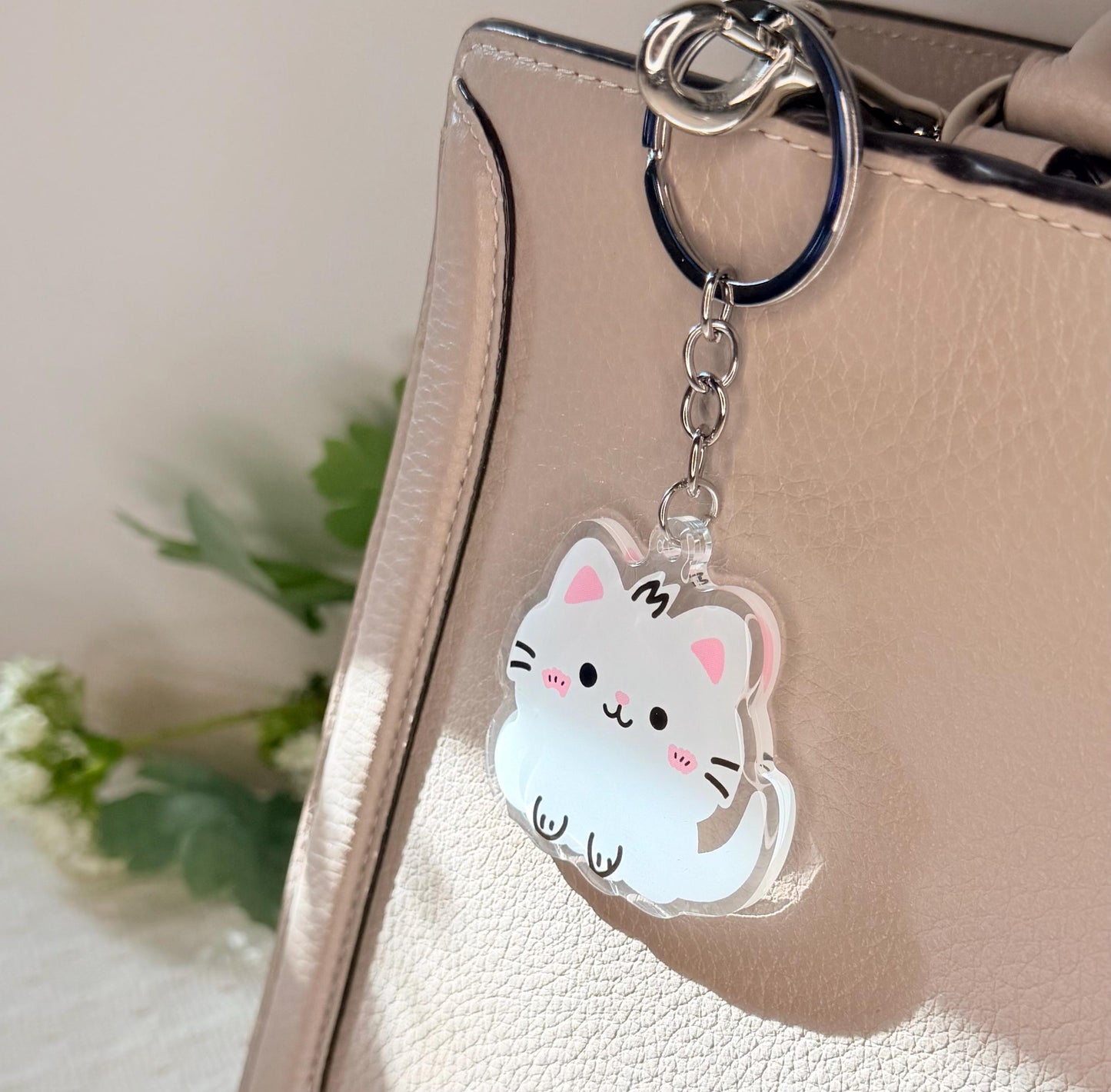 The white kitten keychain displayed on my purse