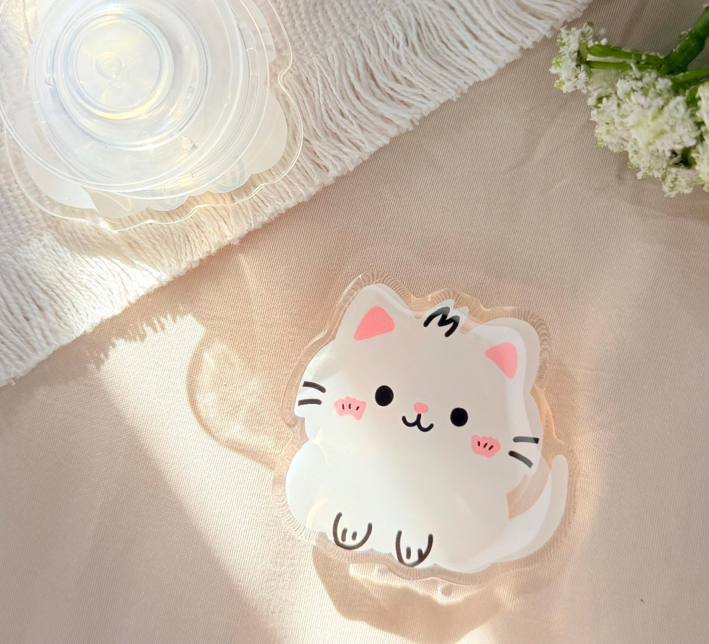 An acrylic foam grip of a Kawaii style white kitten