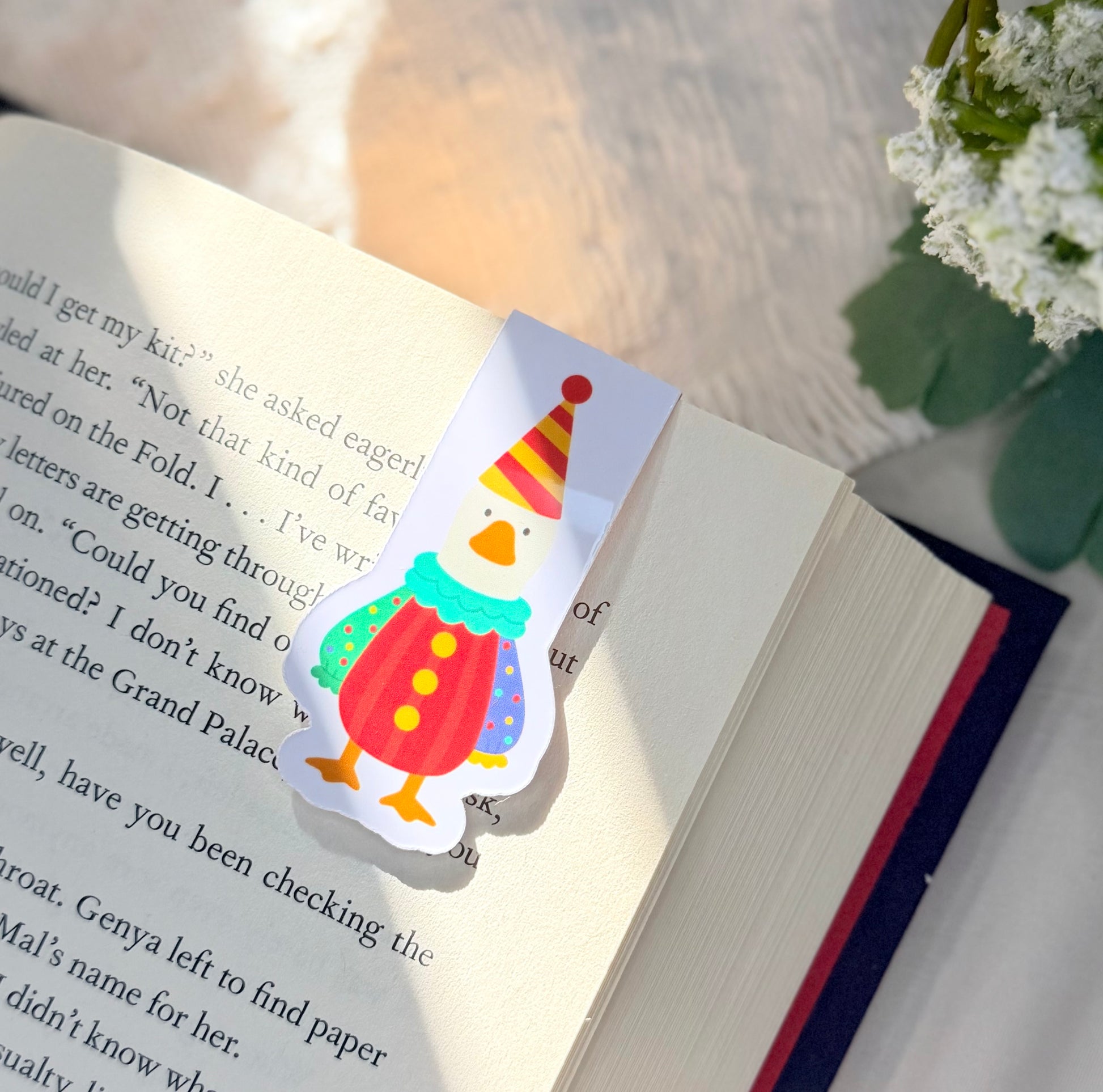 A magnetic bookmark of a silly goose wearing a colorful clown costume