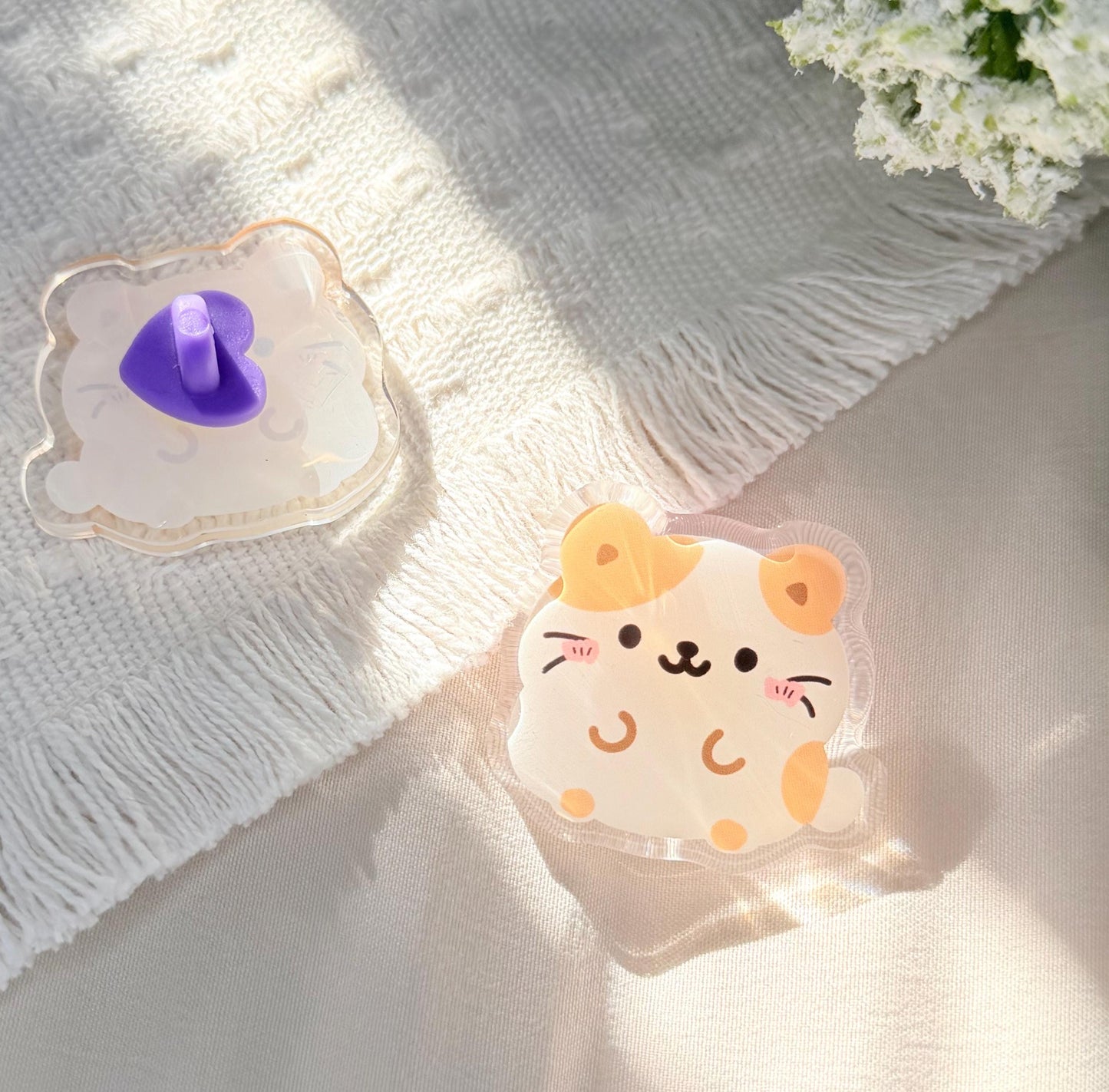 An acrylic pen of a Kawaii style tan and white hamster