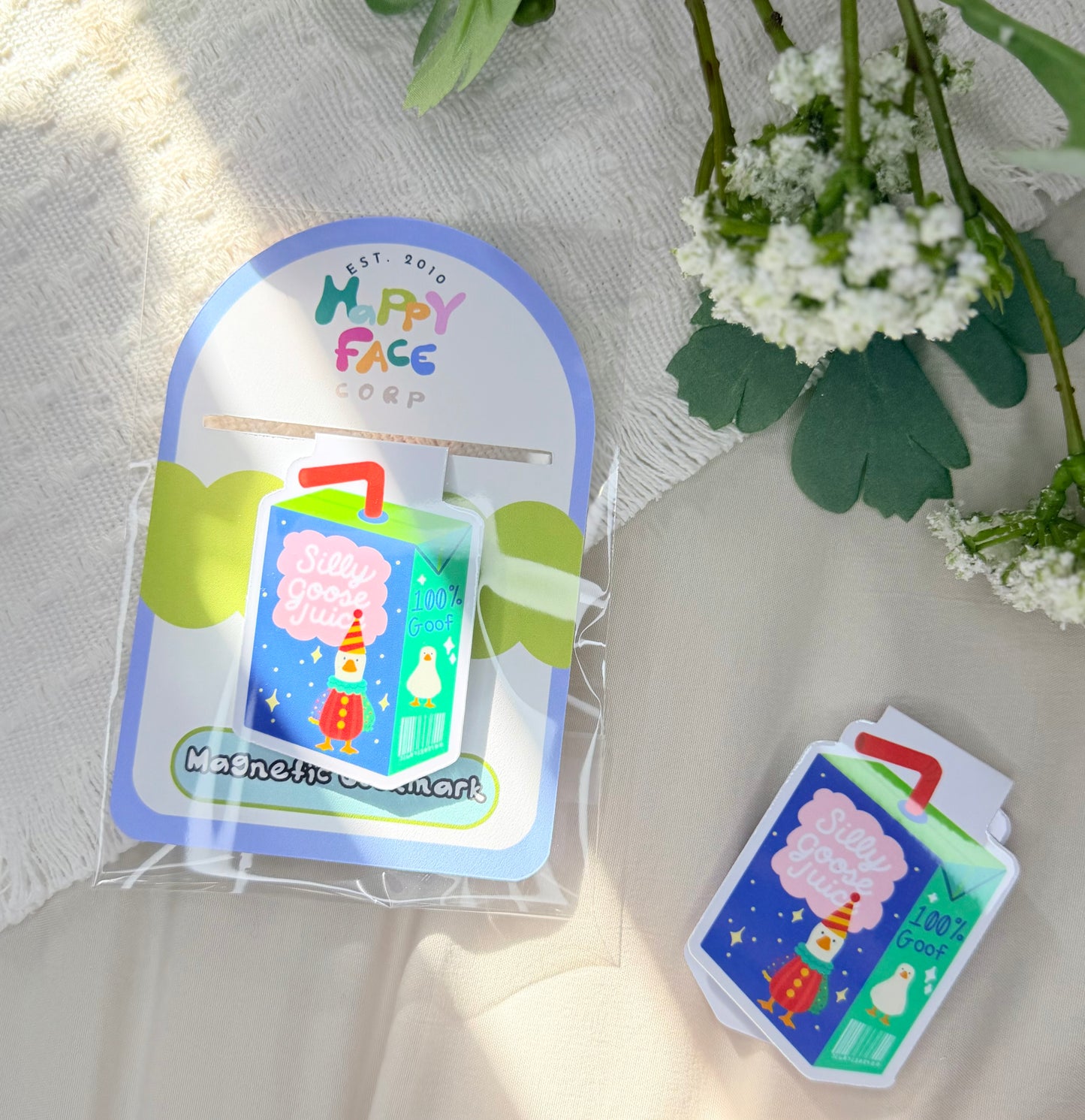 silly goose magnetic bookmark of a blue and green juice box with the goose wearing a colorful clown costume