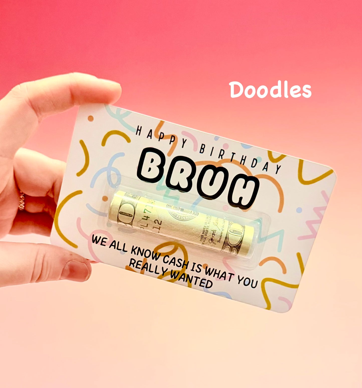 Hand holding a small package with birthday message on a pink background