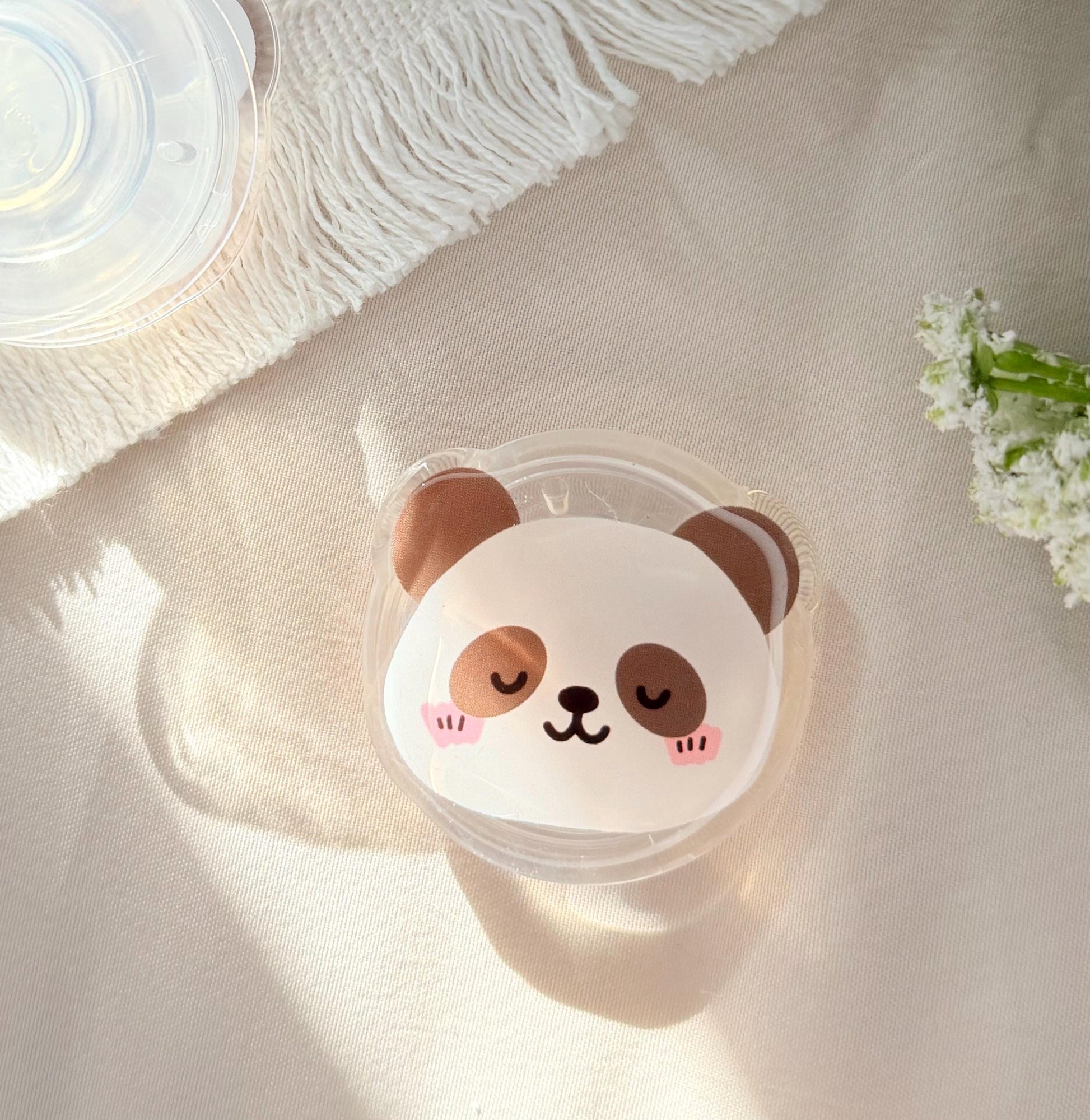 An acrylic foam grip of a Kawaii style panda face