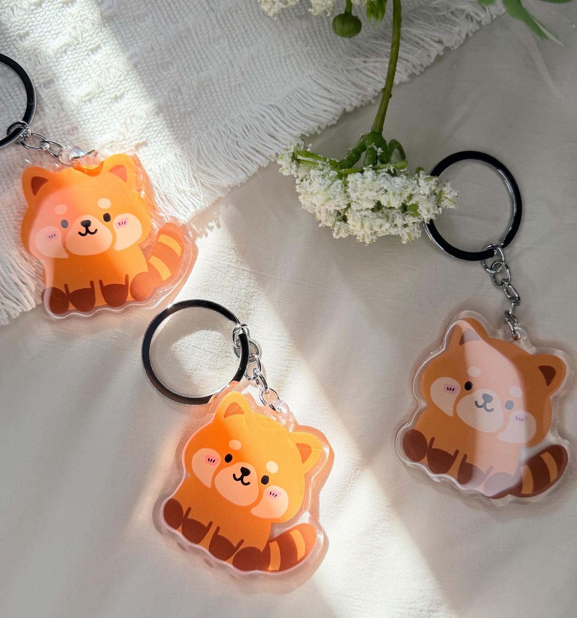 An acrylic keychain of a Kawaii style red panda