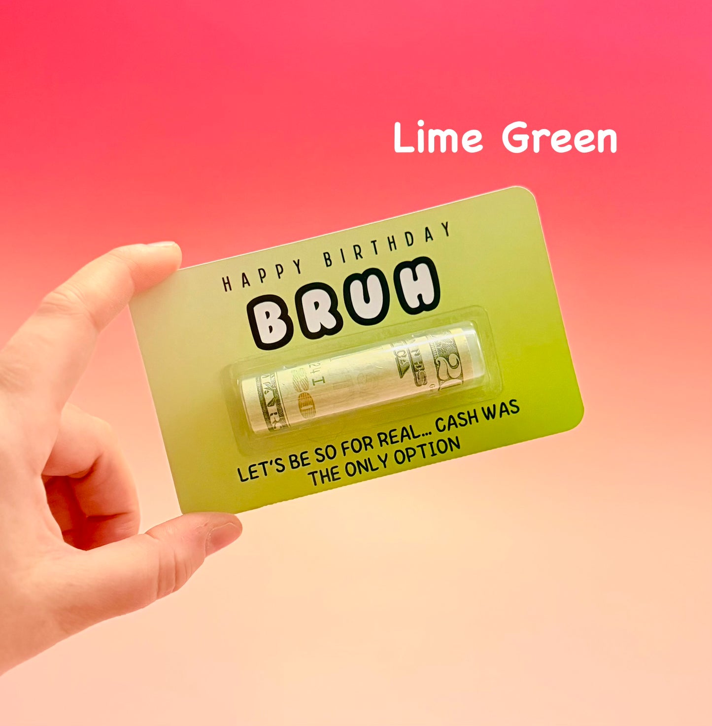 Hand holding a lime green card with text and a small item on a pink gradient background