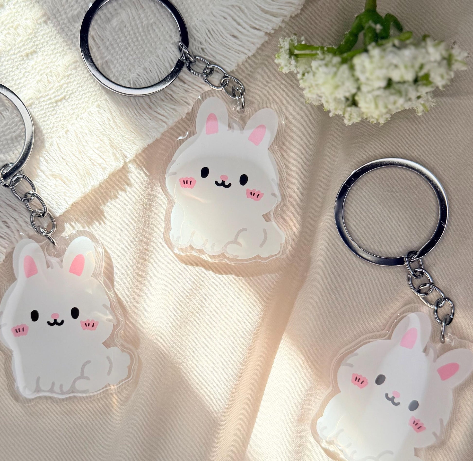 An acrylic Kawaii style white Easter bunny keychain