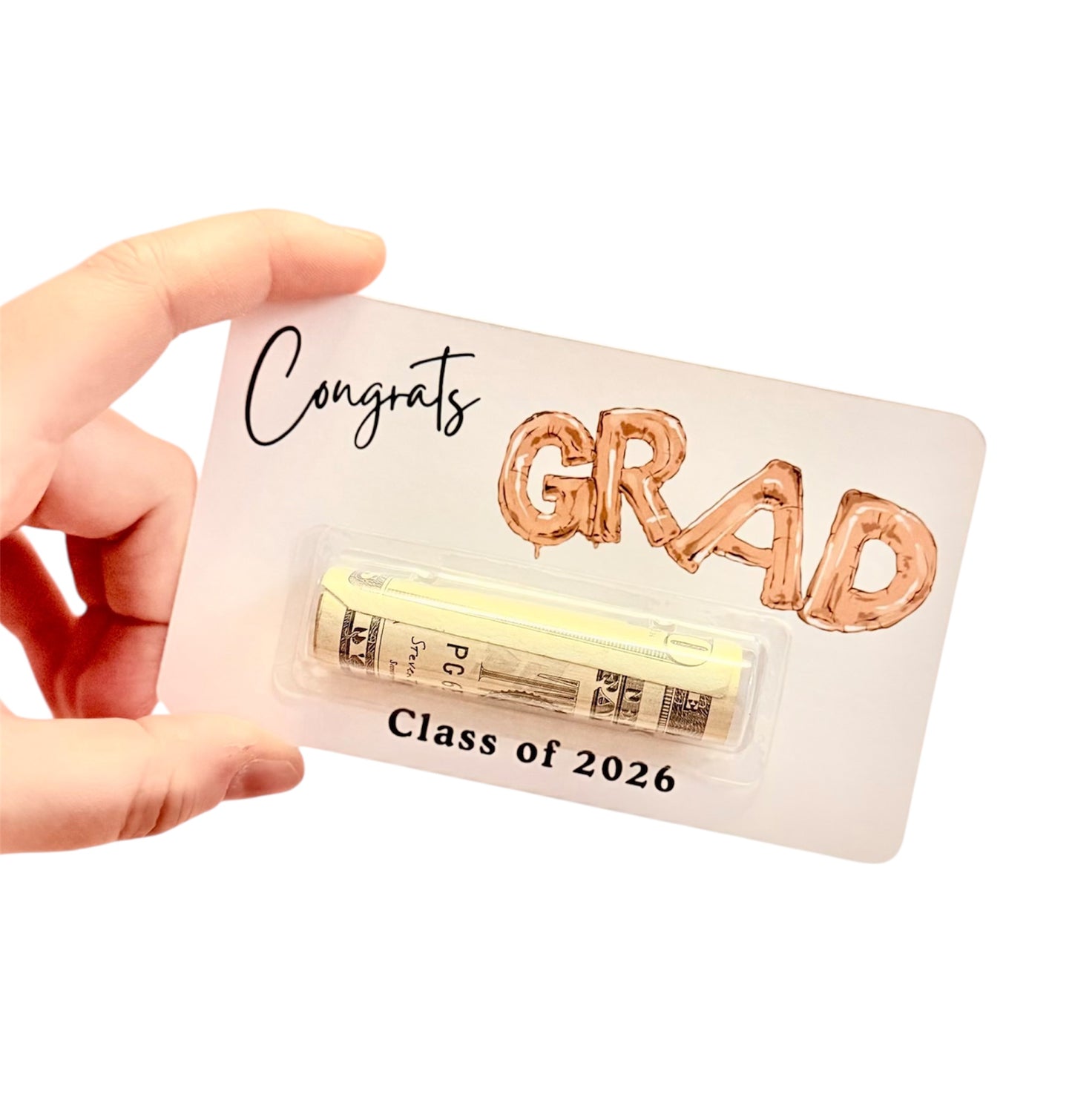 Graduation-themed card with 'Congrats GRAD' text and a small stack of money, held by a hand.