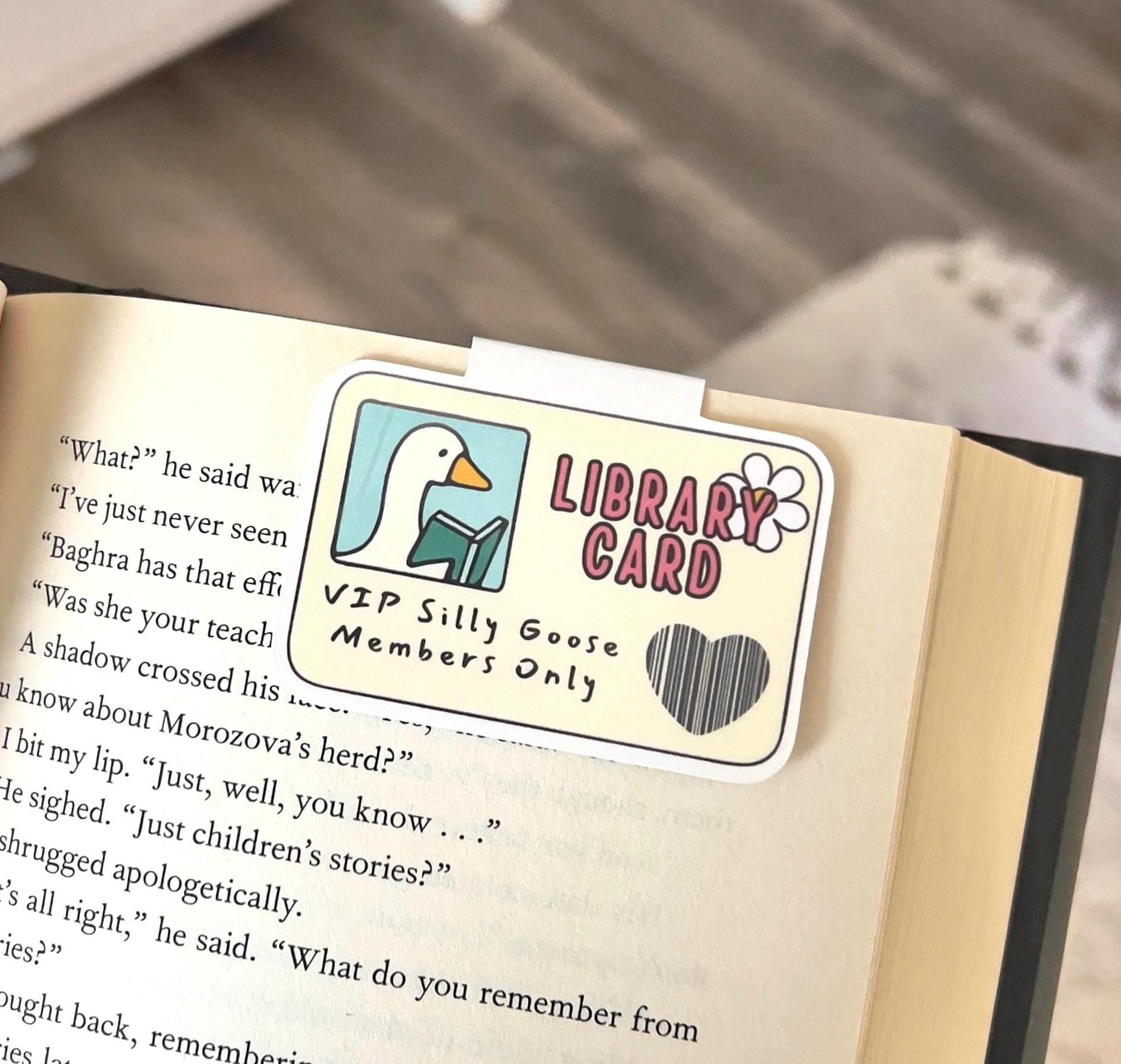 A magnetic bookmark of a silly goose library card, outlined in white