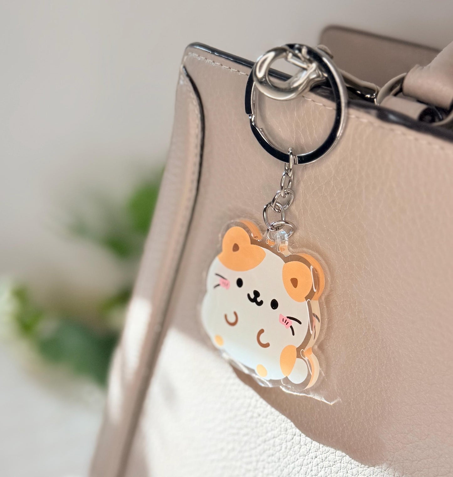 The hamster keychain displayed on a purse
