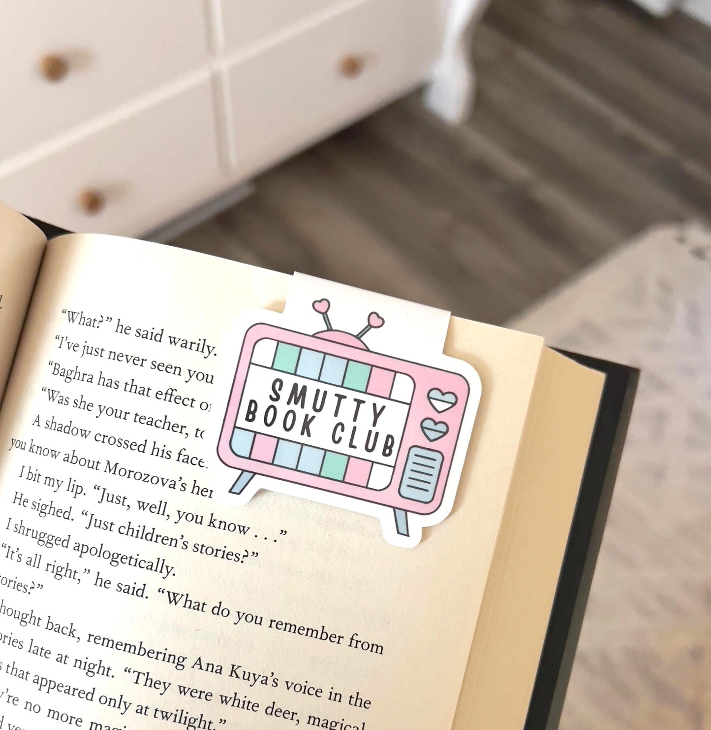 A magnetic bookmark of a cartoon style retro TV that says Smutty book club
