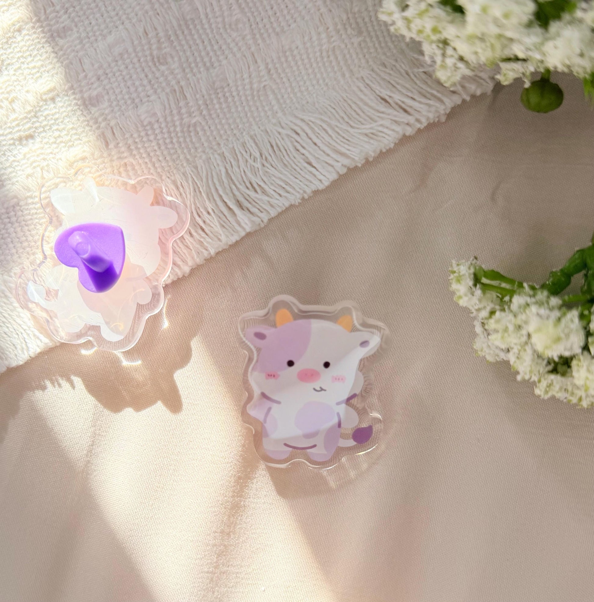 An acrylic pen of a Kawaii style purple spotted cow