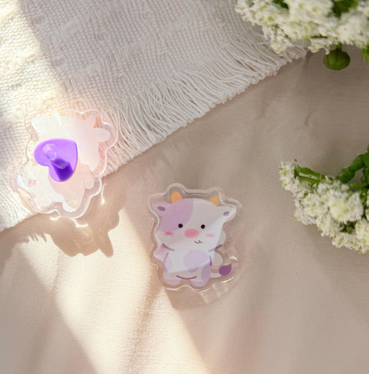An acrylic pen of a Kawaii style purple spotted cow