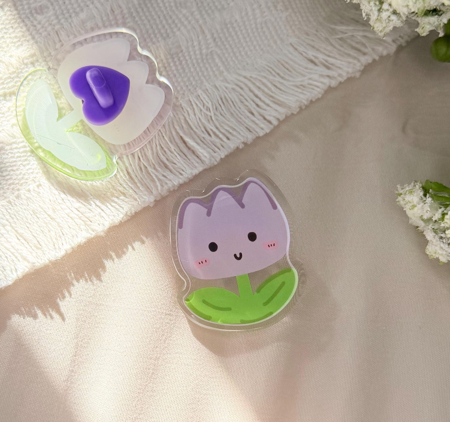 An acrylic pen of a purple Kawaii tulip with a happy face