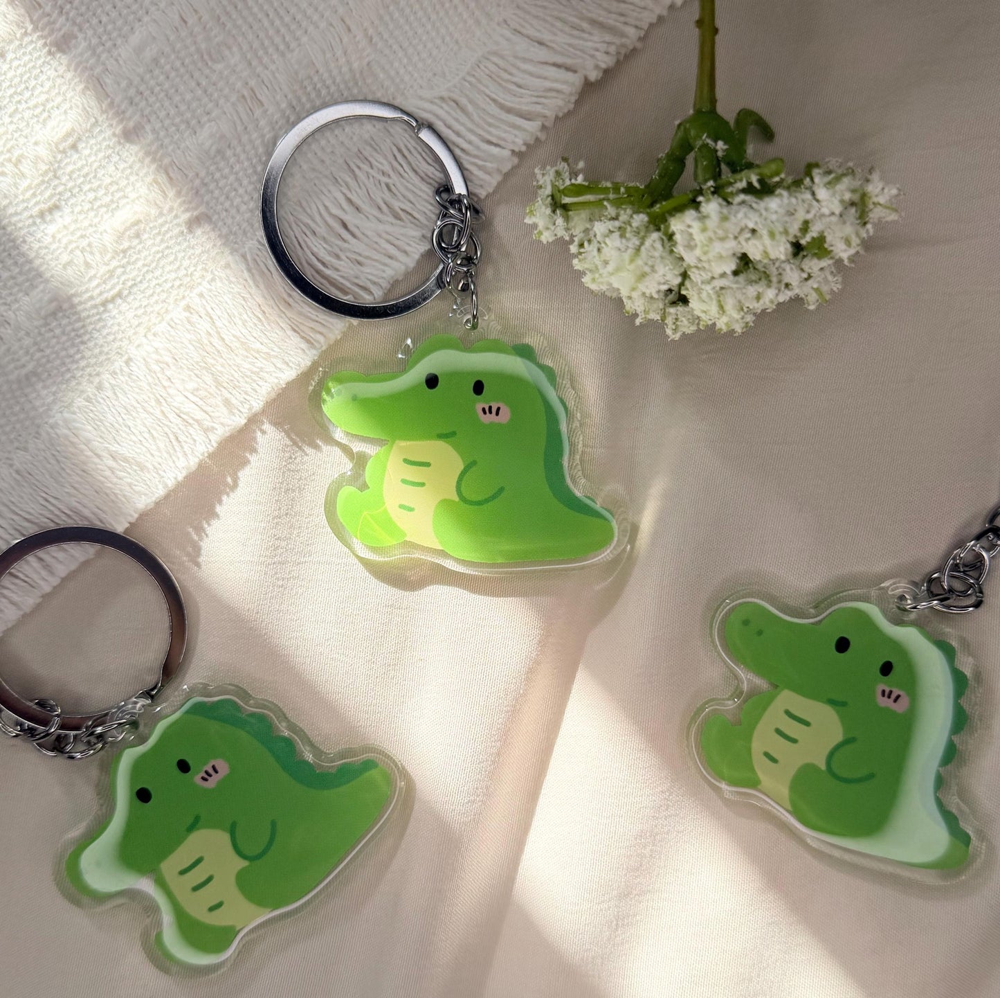 An acrylic keychain of a Kawaii style green alligator