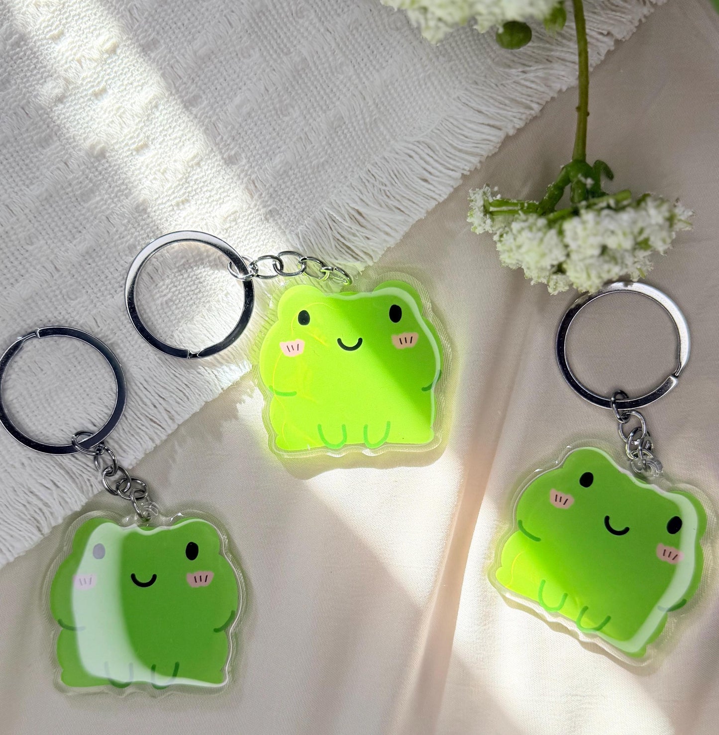 An acrylic keychain of a Kawaii style green frog