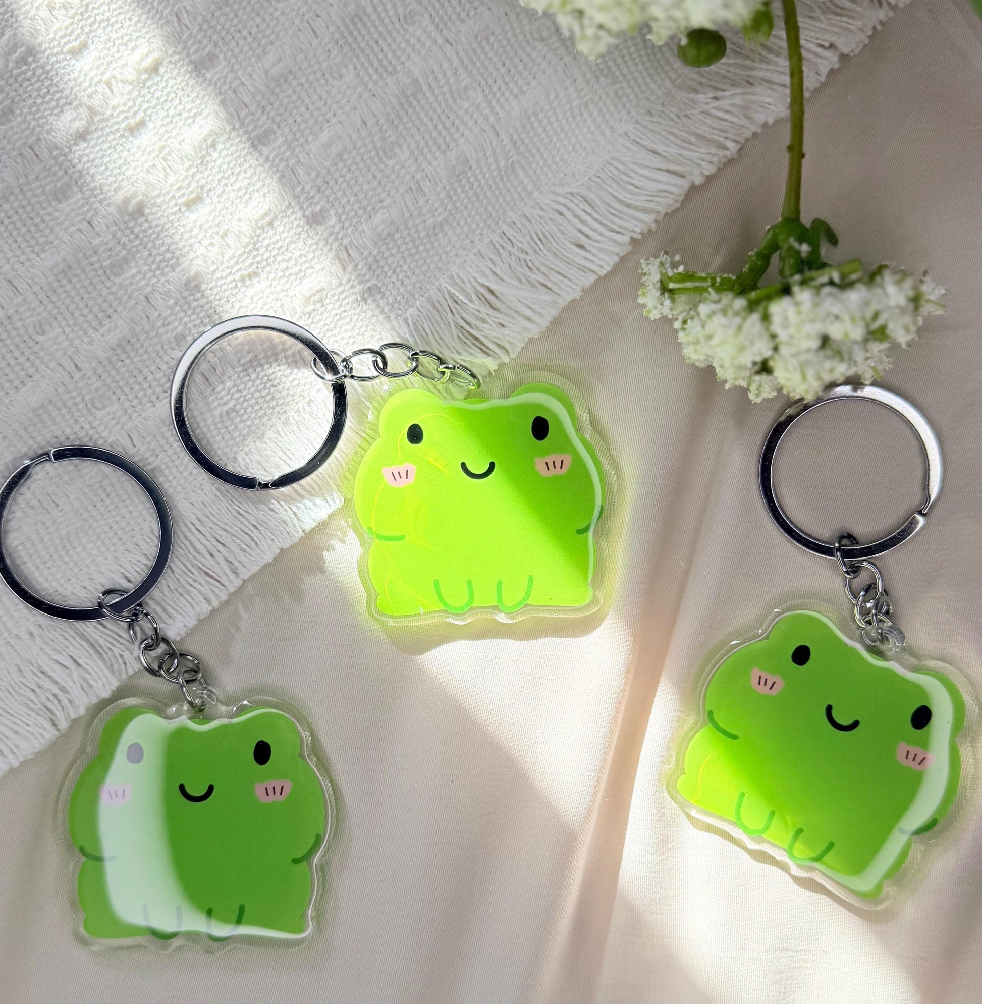 An acrylic keychain of a Kawaii style green frog