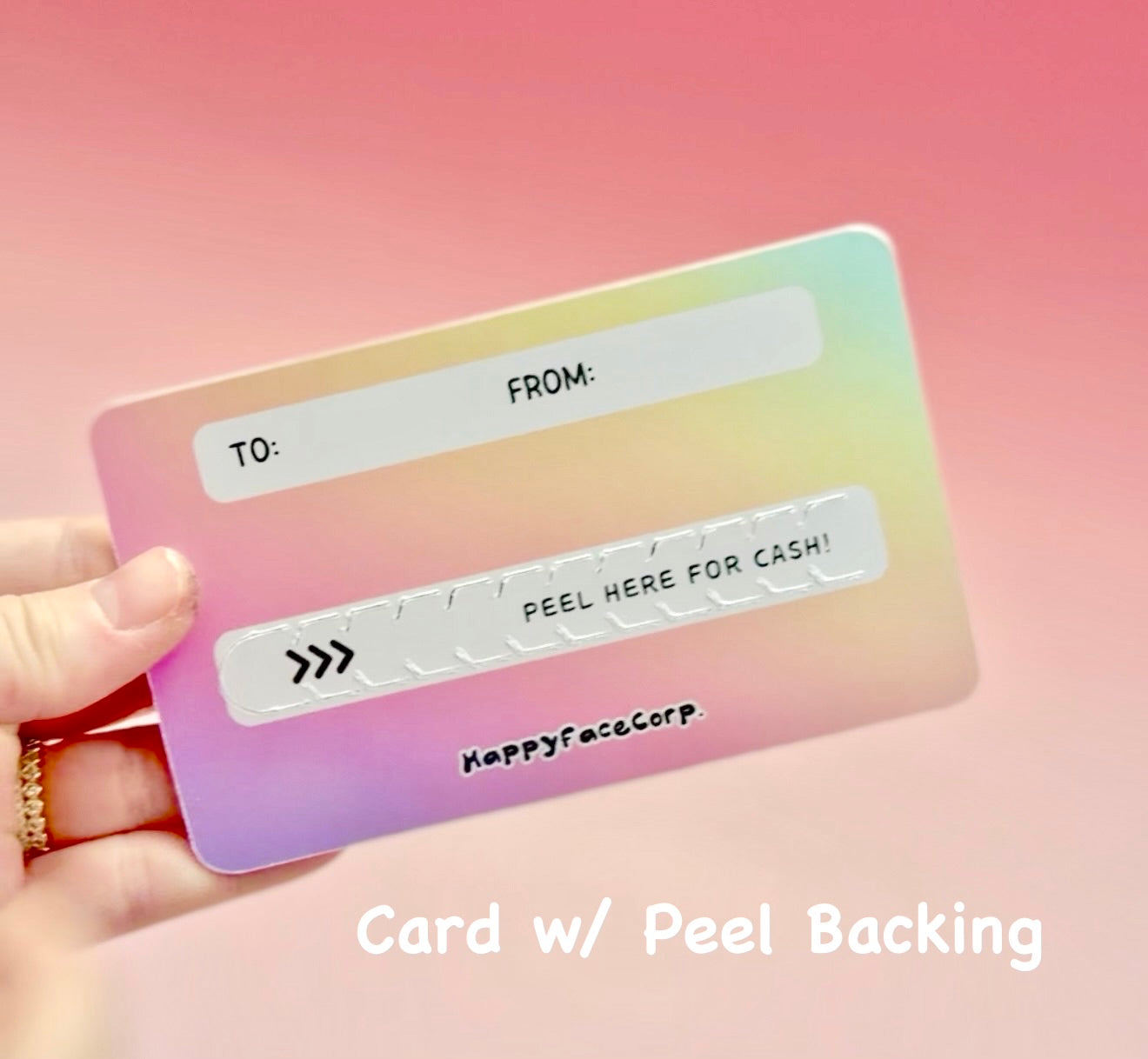 Card with peel backing held by a hand against a pink background