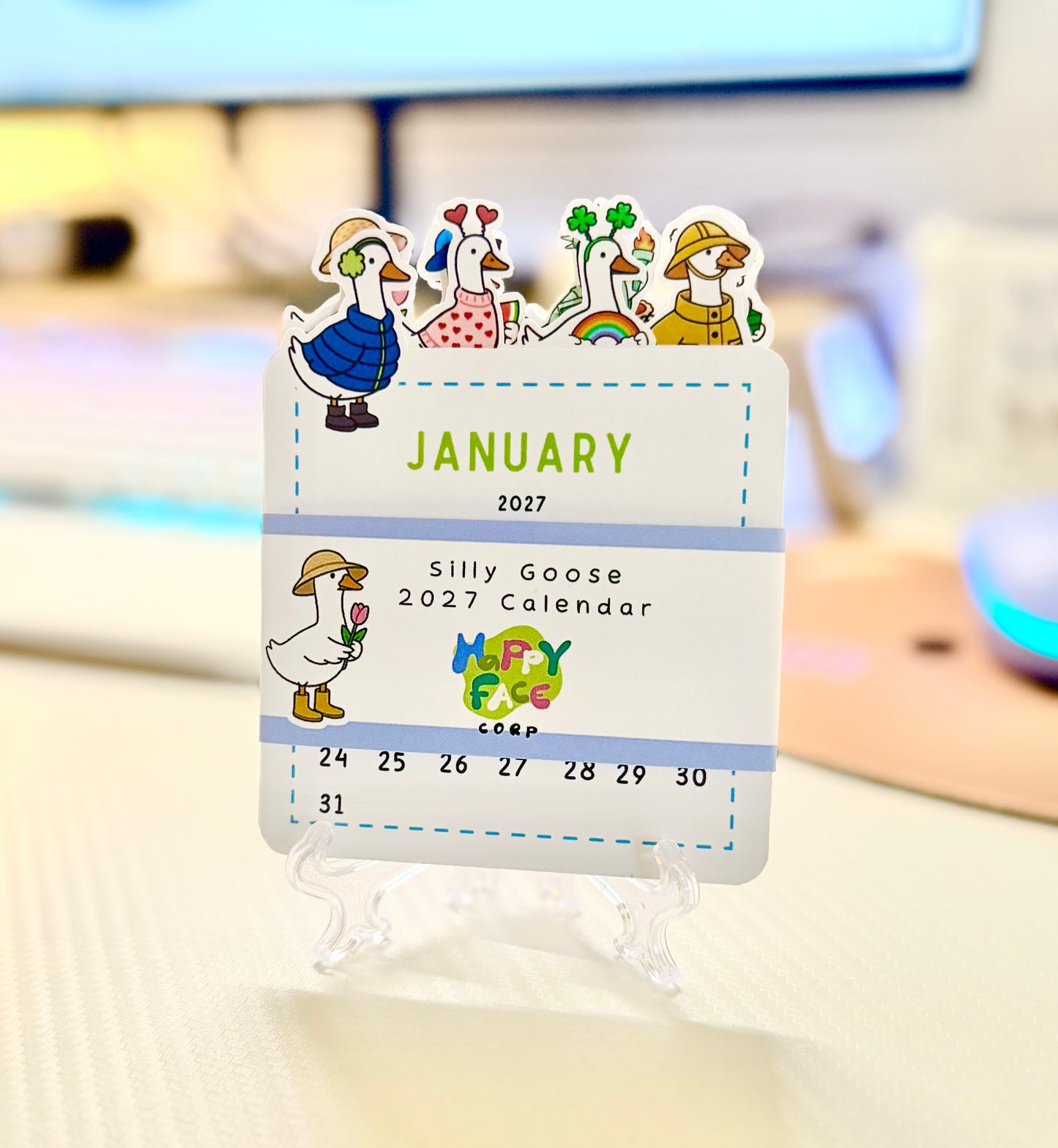 Desk calendar with cartoon characters for January 2027 on a stand.