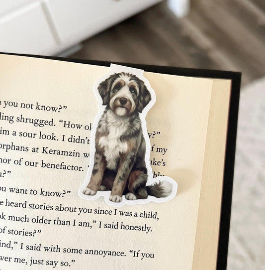 A magnetic bookmark of a semi realistic, cartoon style brown Merle Aussie doodle