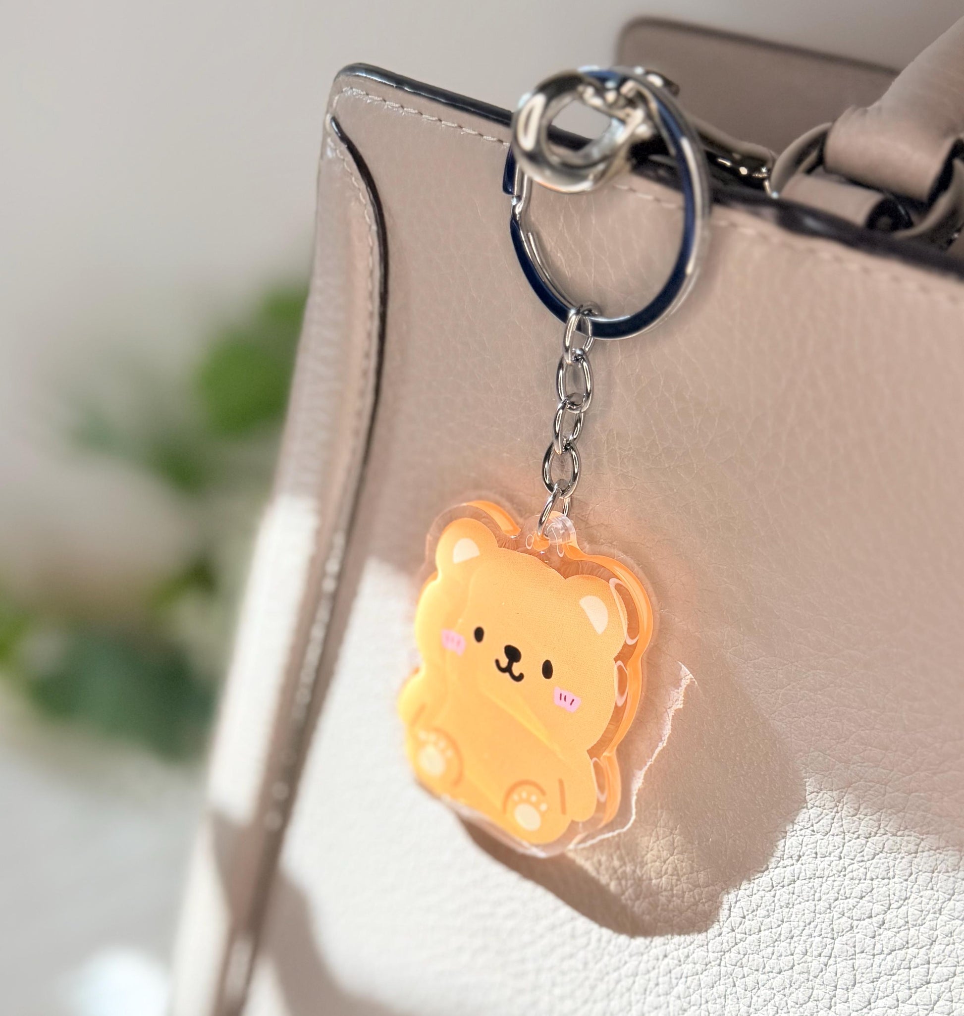 The brown bear keychain displayed on a purse