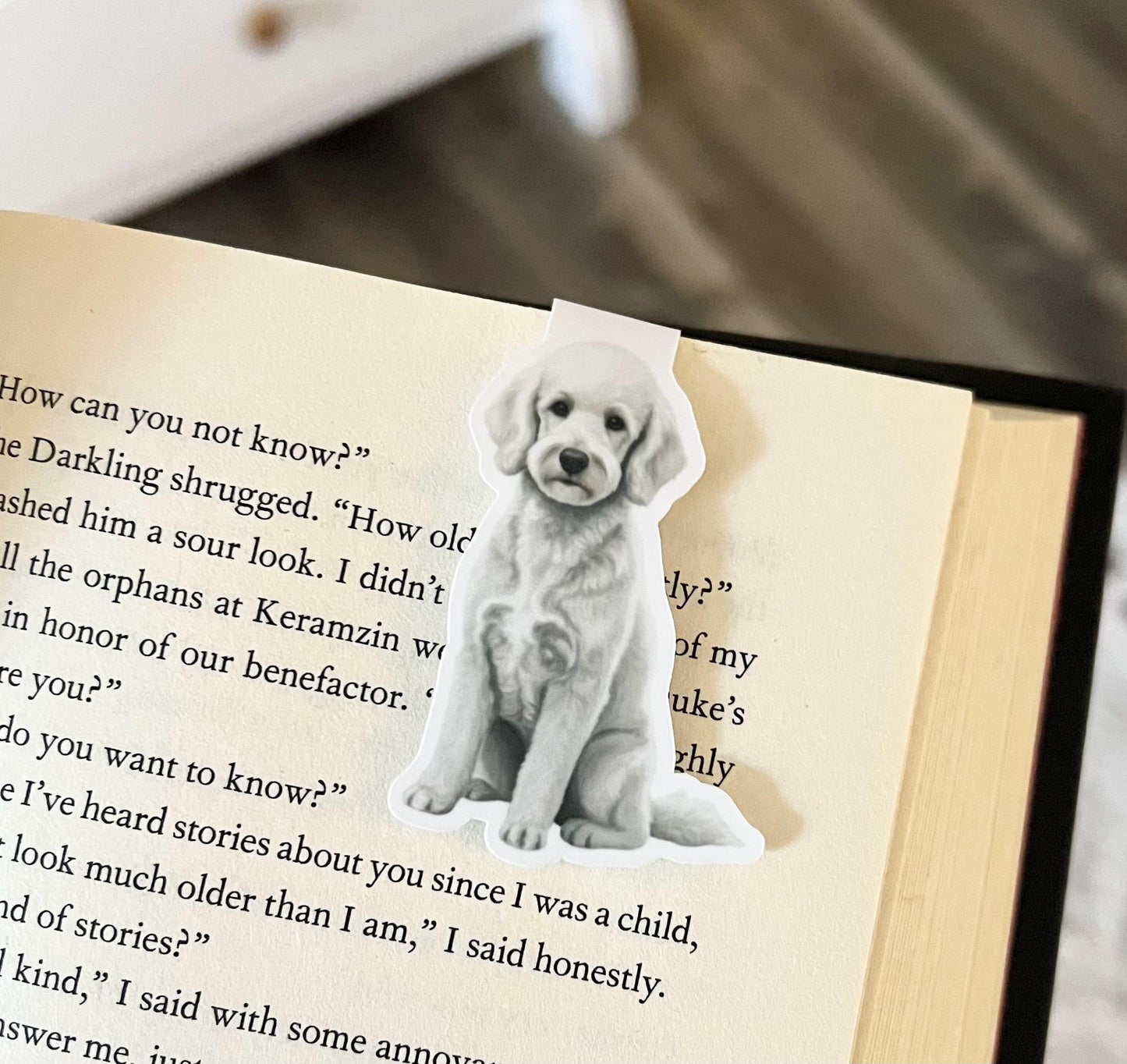 A magnetic bookmark of a semi realistic, cartoon style white poodle