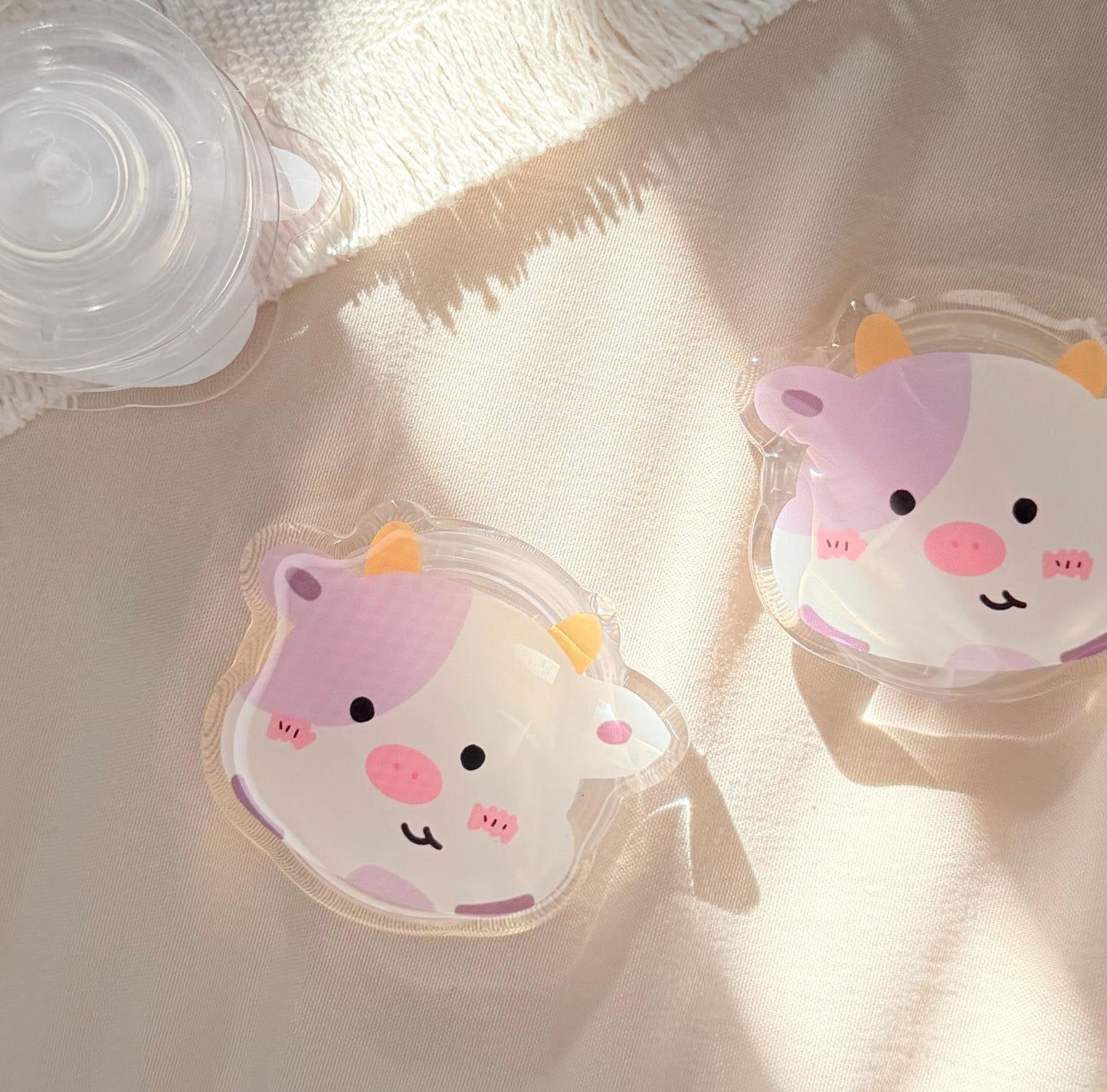 An acrylic foam grip of a Kawaii style purple spotted cow face