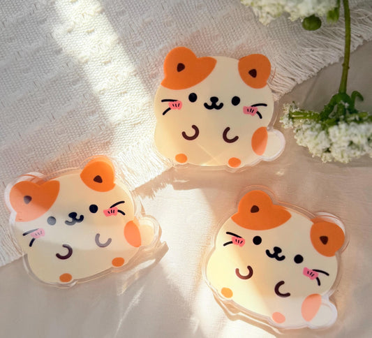 An acrylic binder, clip or chip clip of a Kawaii style tan and white hamster