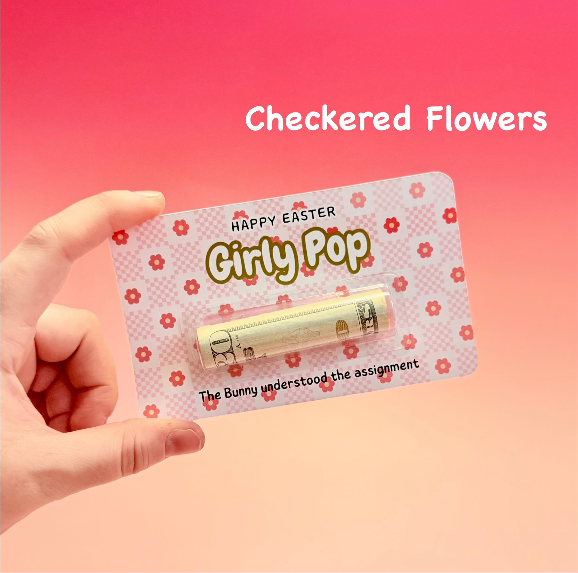 Hand holding a product with 'Happy Easter Girly Pop' packaging against a pink background