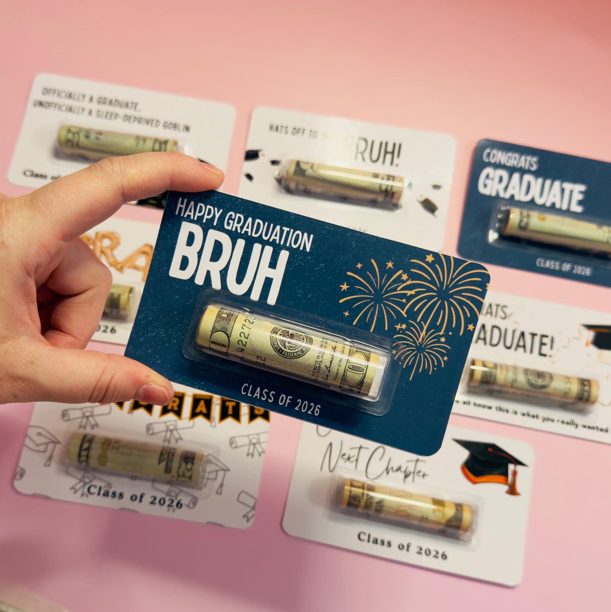 Graduation-themed gift card with 'Happy Graduation Bruh' text and gold tube on a pink background.