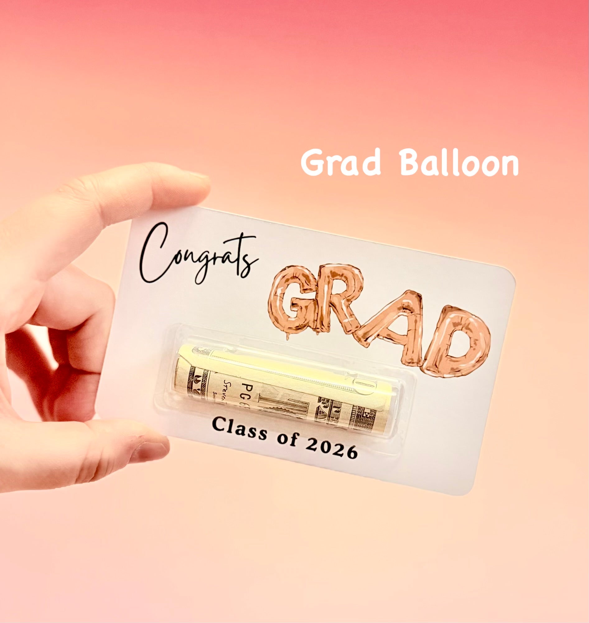 Graduation-themed balloon kit with 'GRAD' letters on a pink background