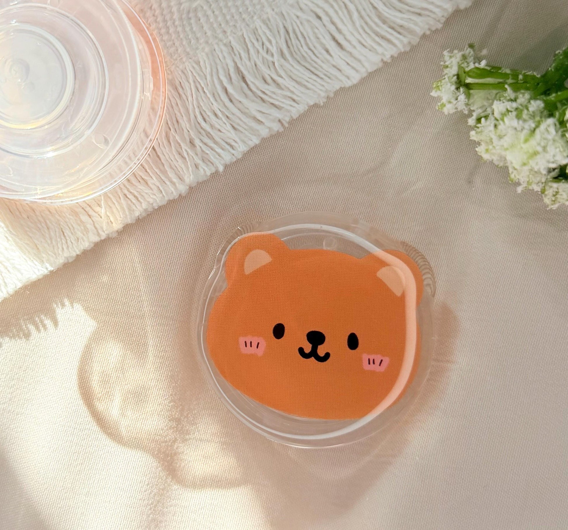 An acrylic foam grip of a Kawaii style brown bear face
