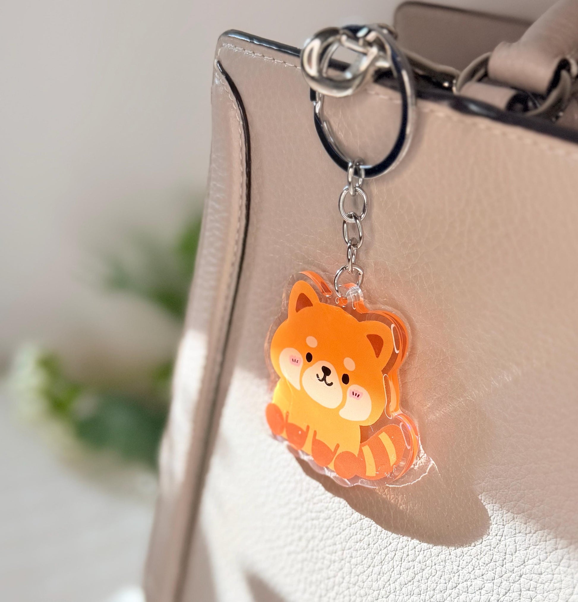 The red Panda keychain displayed on a purse