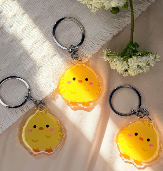 An acrylic keychain of a Kawaii style yellow baby chick