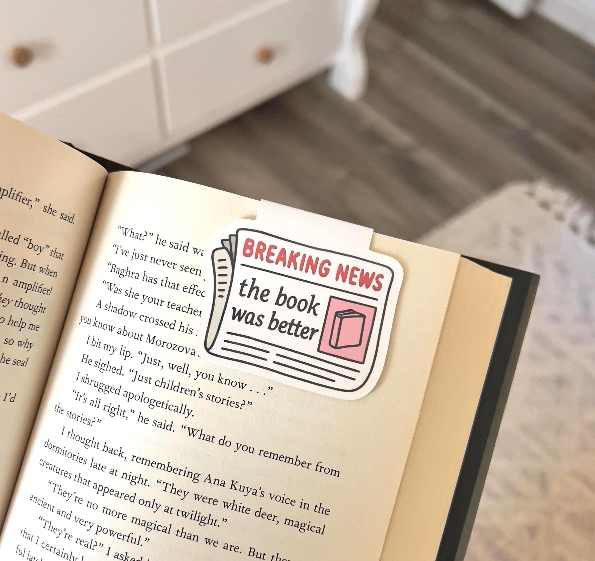 A magnetic bookmark of a cartoon style newspaper that says breaking news the book was better