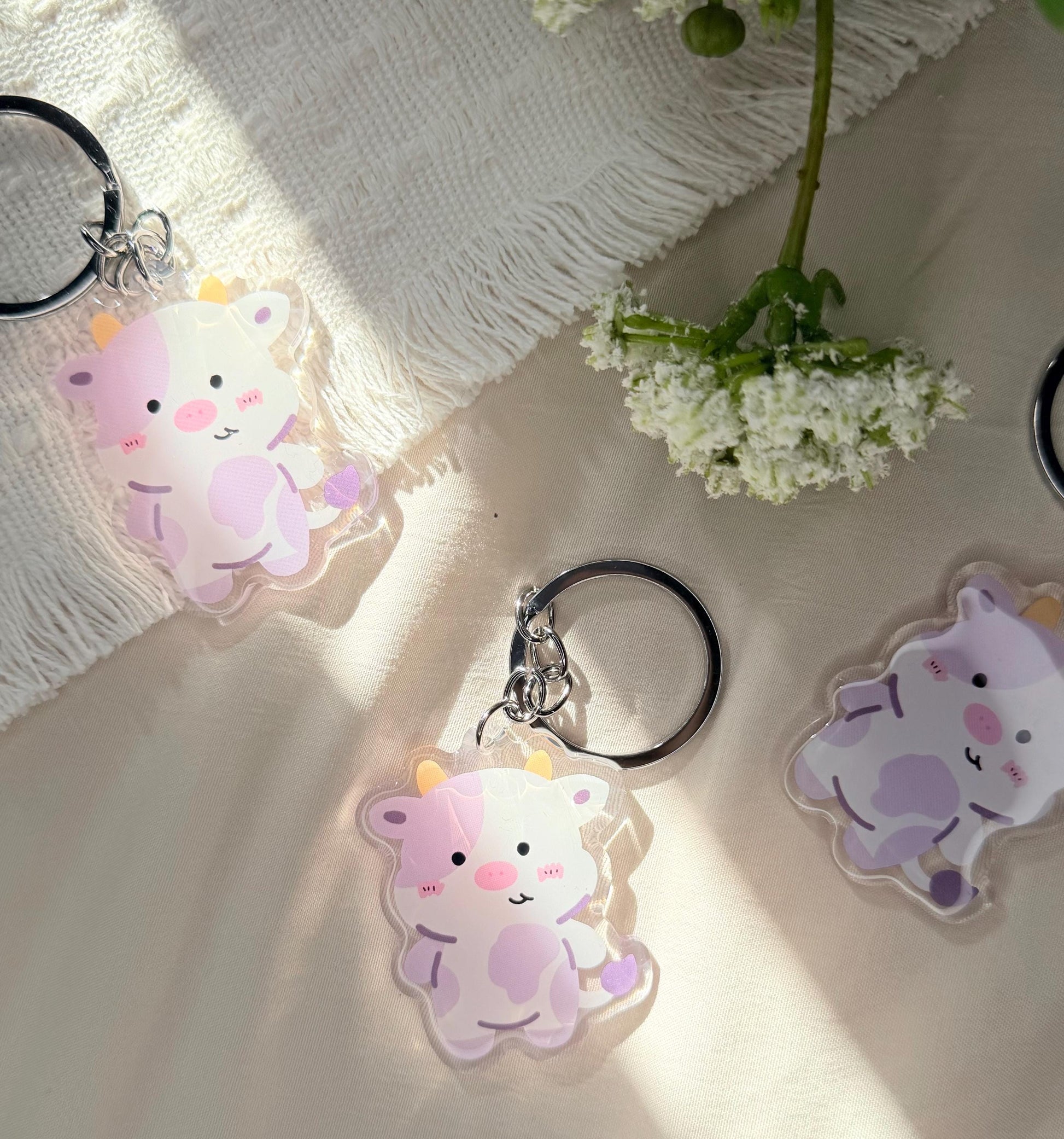 An acrylic keychain have a Kawaii style purple spotted cow