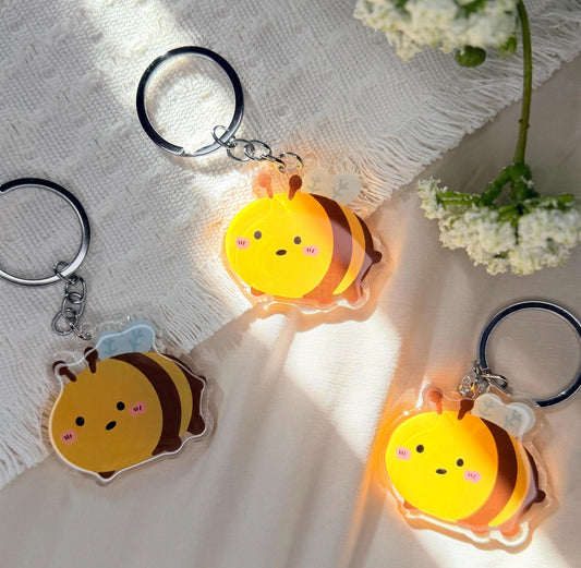 An acrylic keychain of a Kawaii style, yellow and black bumblebee
