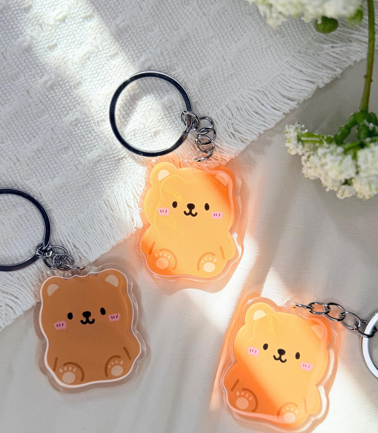 An acrylic keychain of a Kawaii style brown bear