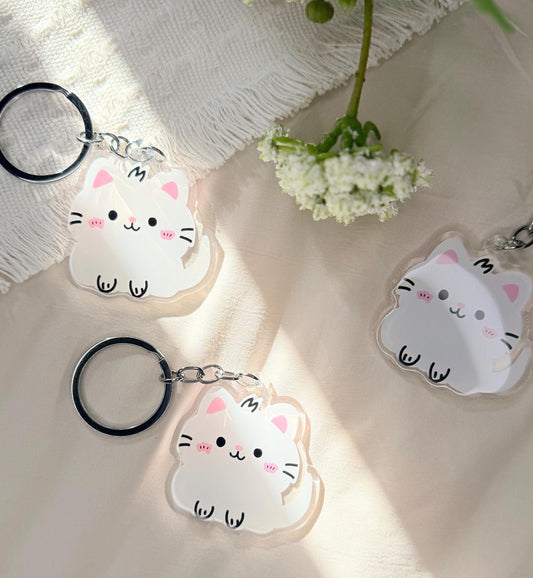 An acrylic keychain of a Kawaii style white kitten