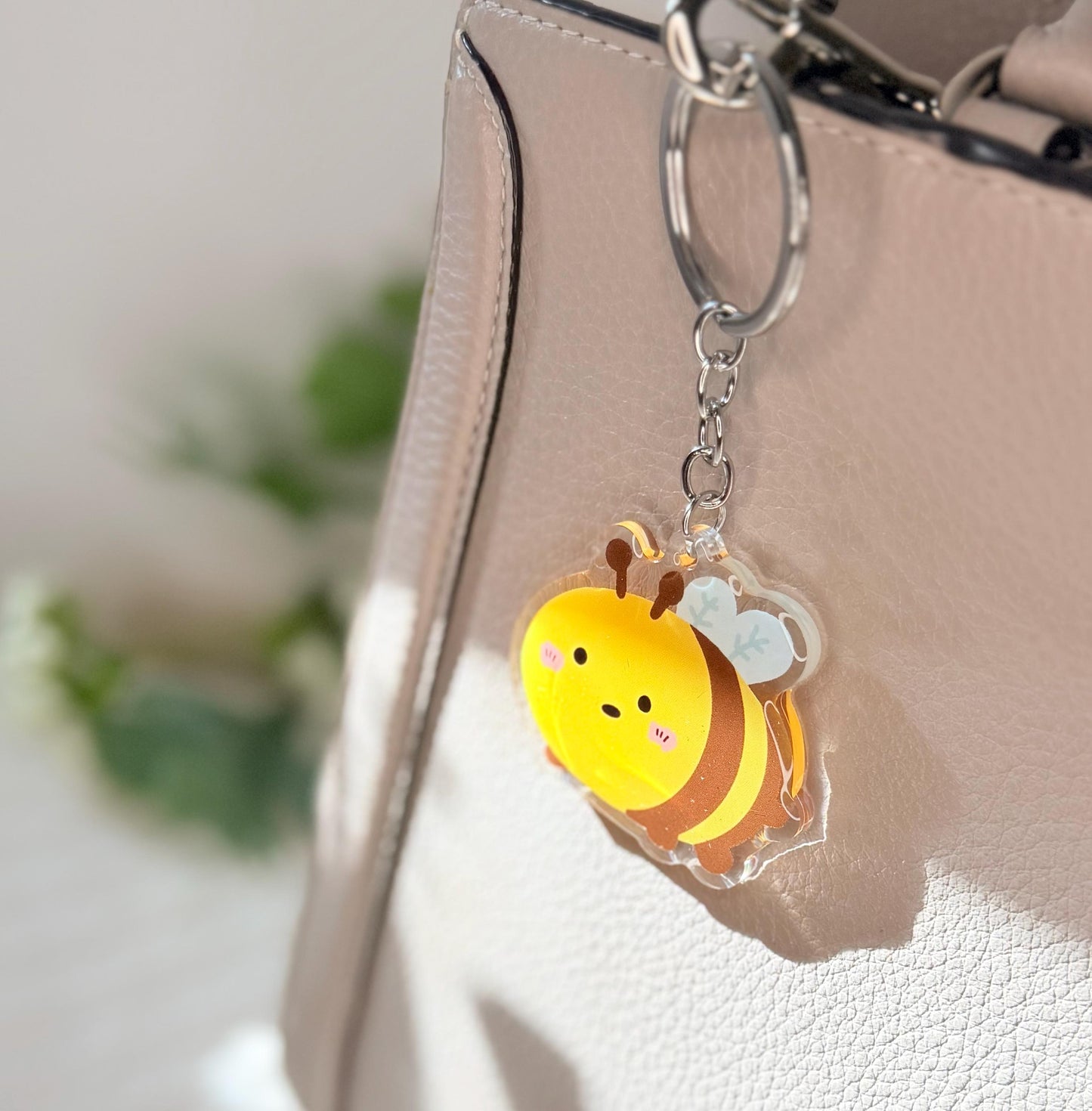 The bumblebee keychain displayed on a purse